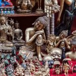 A display of assorted Buddha figurines, statues and singing bowls.