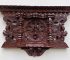 Intricately carved dark wooden decorative wall piece.