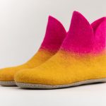 Pair of handmade felt slippers in mustard yellow and bright pink.