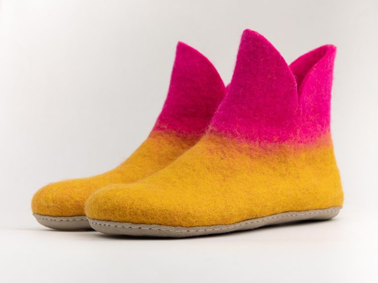 Pair of handmade felt slippers in mustard yellow and bright pink.
